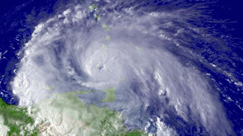 Hurricane Ivan just west of Grenada. north of Trinidad and Tobago, in the Caribbean Sea on September 7, 2004, at 19:45 UTC (15:45 AST). At the time, Ivan had maximum sustained winds of 120 mi/h (195 km/h), placing it at Category 3 on the Saffir-Simpson Hurricane Scale. At the time, Ivan was located at about 11.9° N, 61.2° W. Photo as taken from a satellite with the GOES-12 1 km visible imagery.