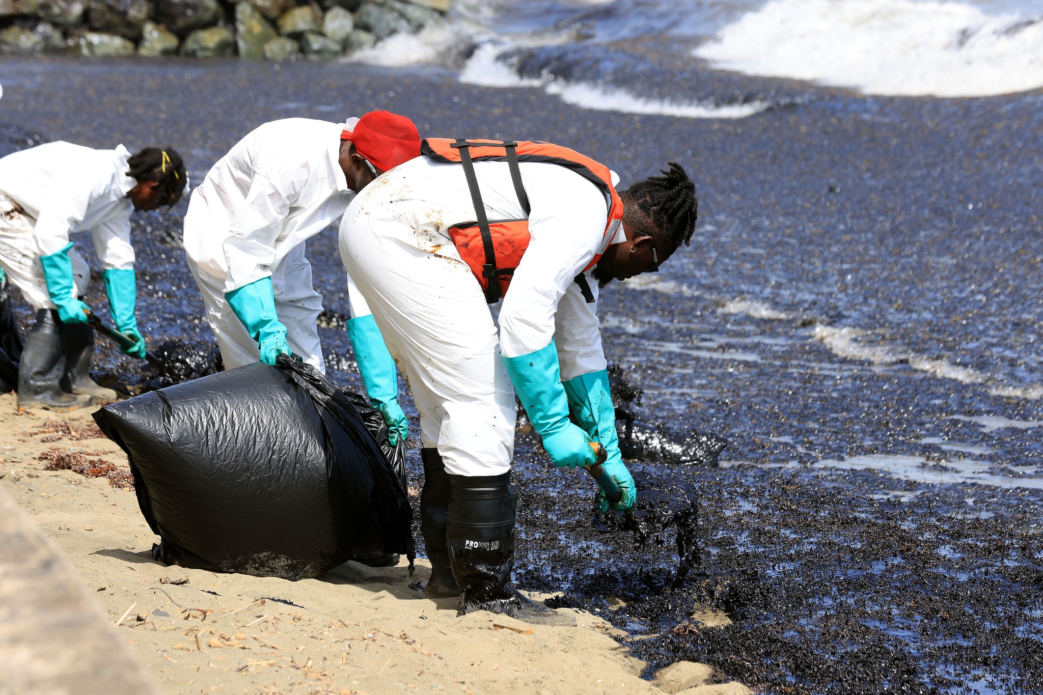Clean-up in Scarborough, Tobago as an oil-like substance washes up on shore, saturating Sargassum